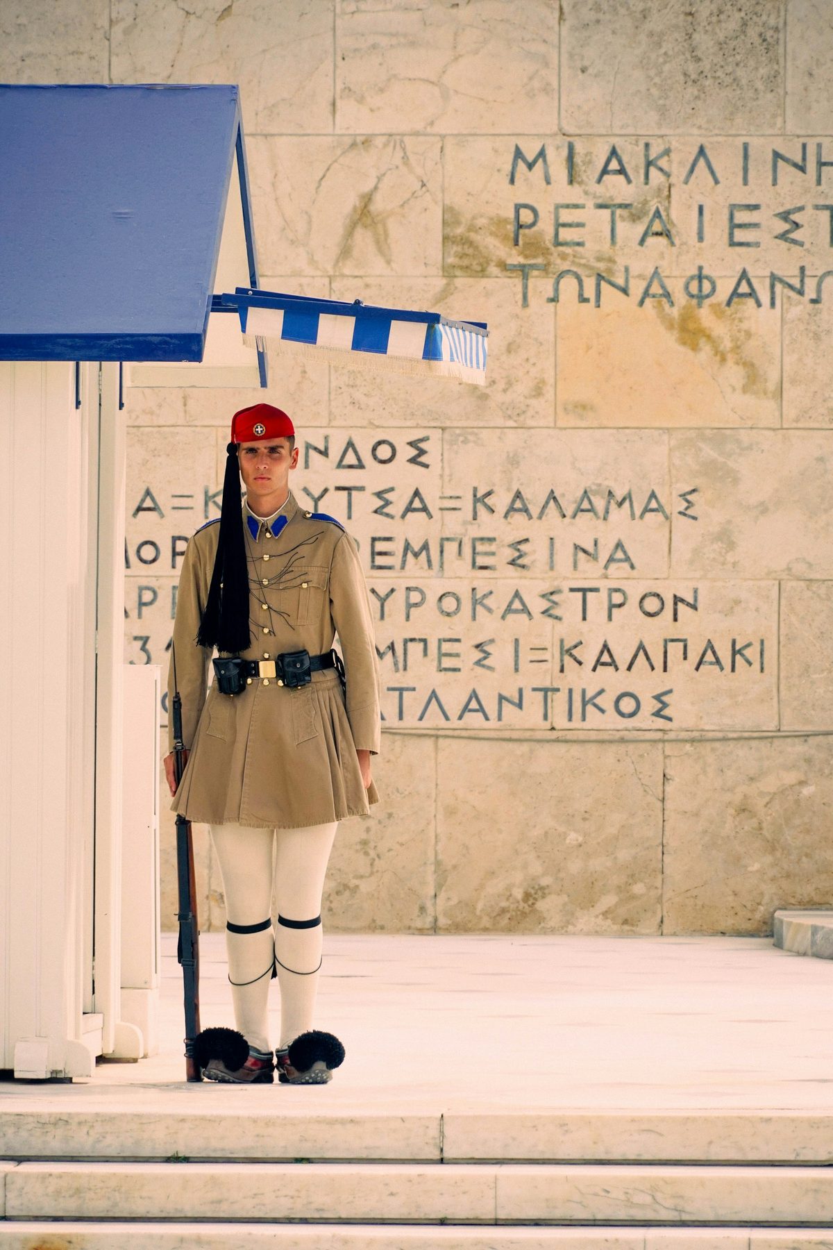 Evzón v slávnostnej uniforme stráži hrob neznámeho vojaka pred parlamentom na Syntagme.