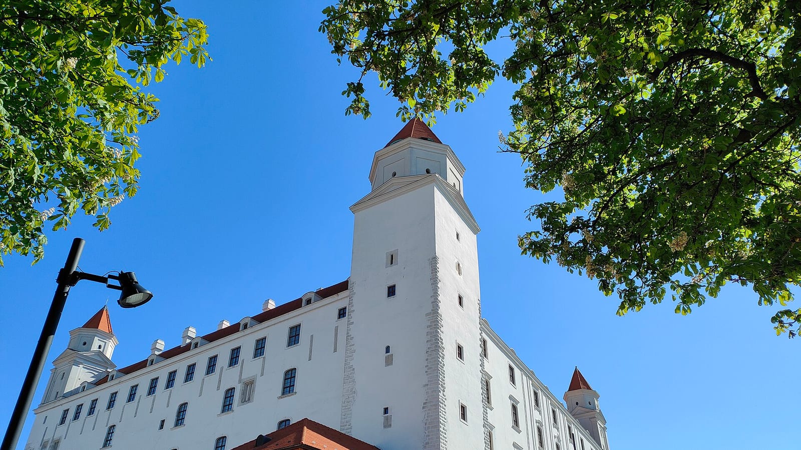 Bratislavský hrad s bielymi múrmi a vežou pod modrou oblohou