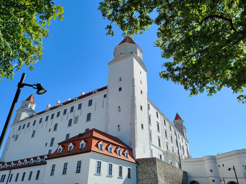 Bratislavský hrad s bielymi múrmi a vežou pod modrou oblohou