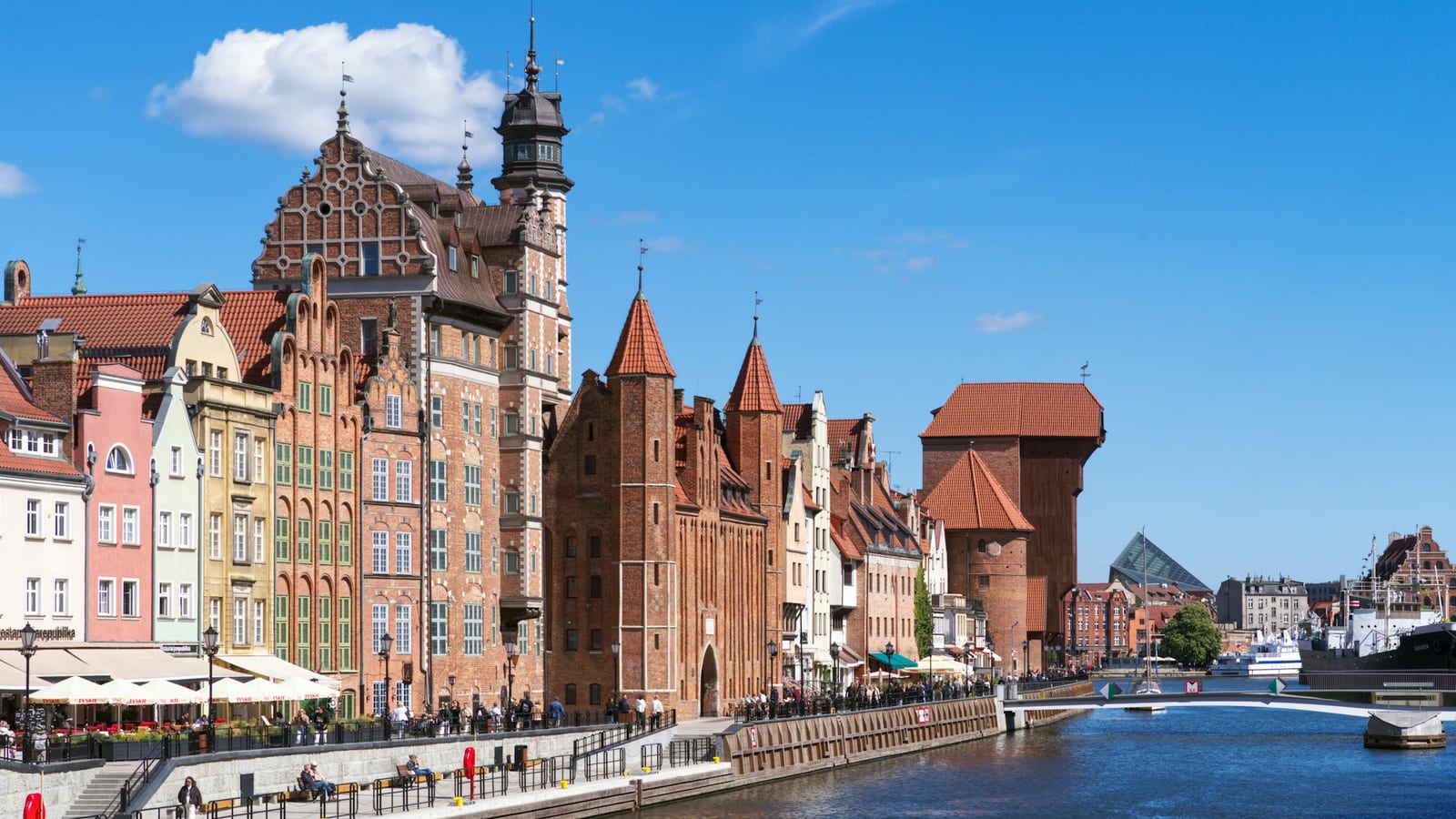 Nábrežie Motławy v Gdansku s farebnými meštianskymi domami, Mariánskou bránou a stredovekým žeriavom Żuraw