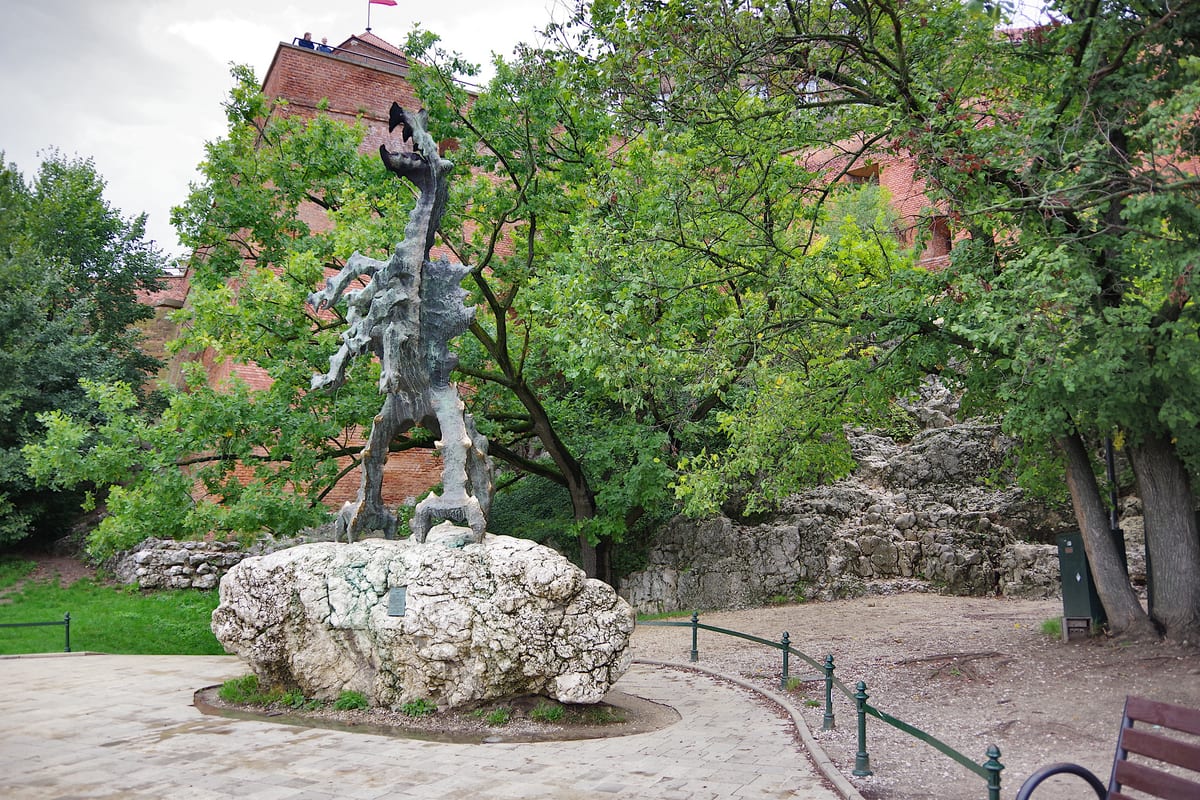 Kovová socha wawelského draka na skale pri Dračej jaskyni pod hradom Wawel