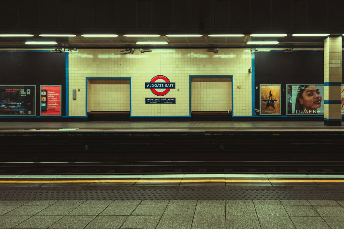 Prázdne nástupište stanice metra Aldgate East so značkou londýnskeho metra