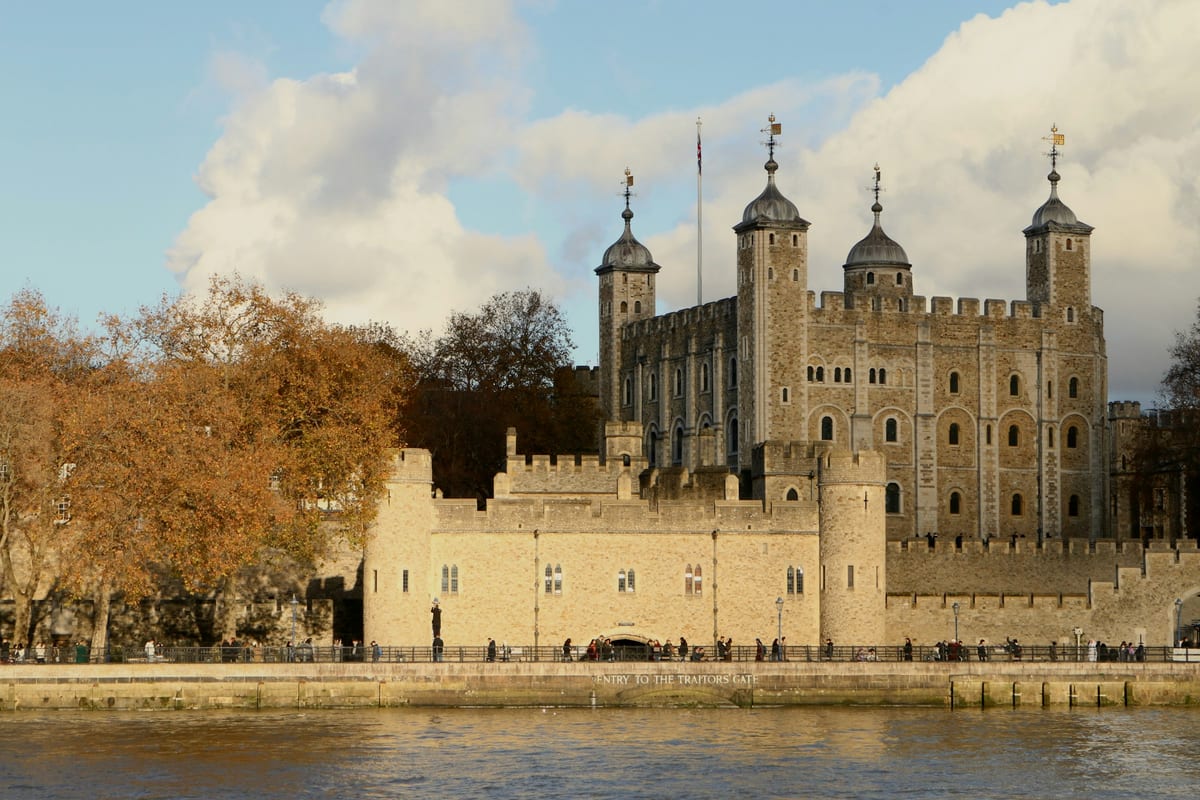 Hradby a Biela veža Tower of London nad Temžou, vpredu stromy v jesenných farbách