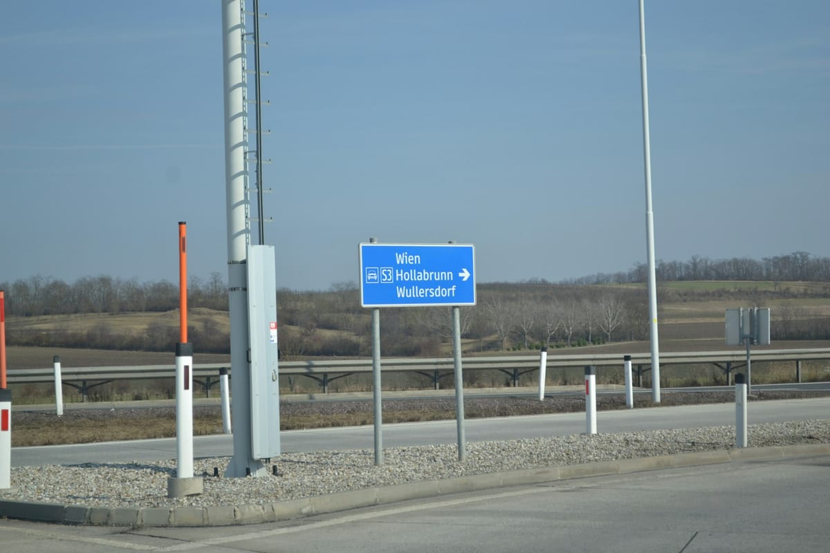Modrá smerová tabuľa pri diaľnici so smerom na Viedeň, Hollabrunn na S3 a Wullersdorf