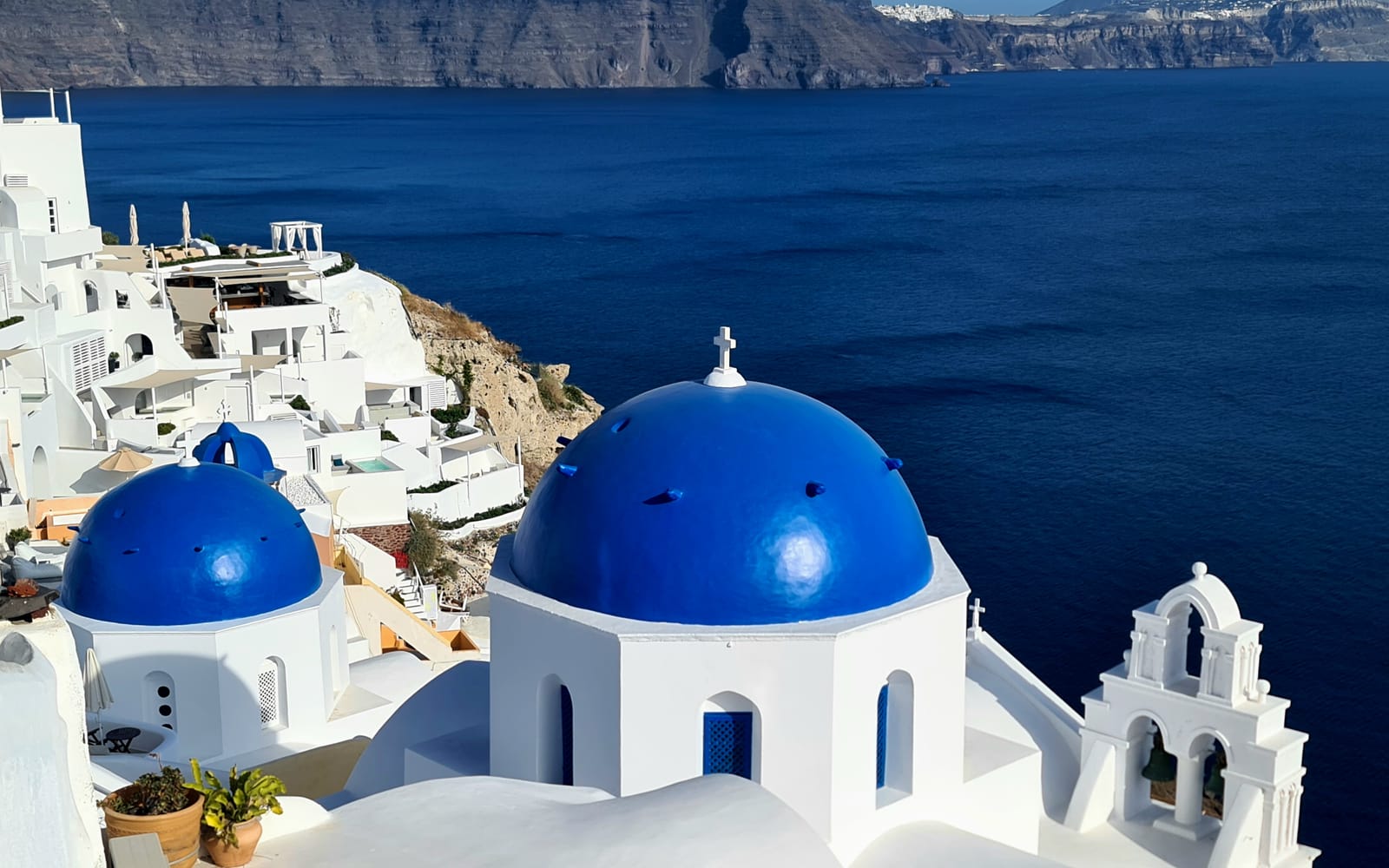 Biele kostoly s modrými kupolami v Oii nad kalderou Santorini