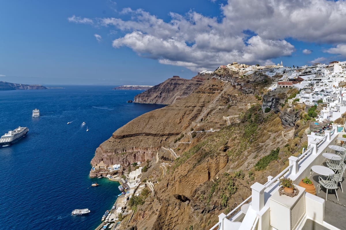 Fira na okraji kaldery Santorini a výletné lode v zálive