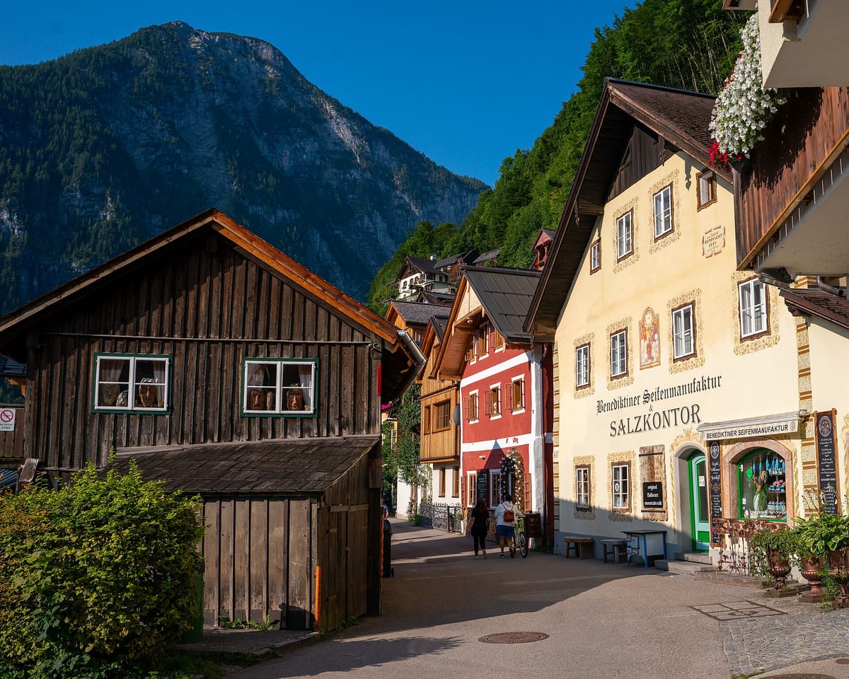Drevené a murované domy na úzkej ulici v Hallstatte ráno, vpravo budova Salzkontor