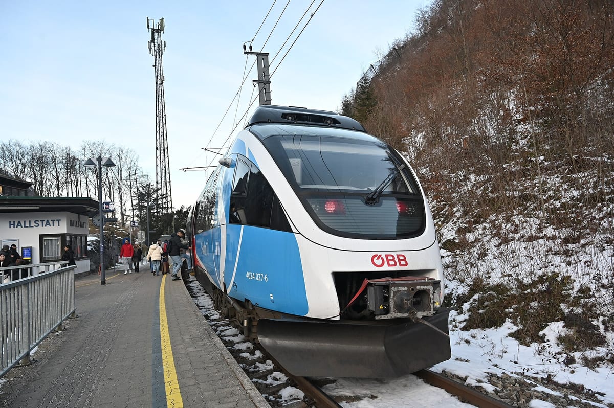 Regionálny vlak ÖBB stojí na malej stanici Hallstatt na druhom brehu jazera