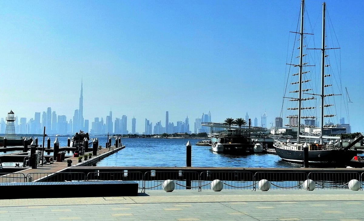 Prístav Dubai Creek Harbour so zakotvenou plachetnicou a panorámou Dubaja s Burdž Chalífou