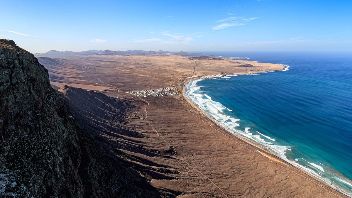 Pláž Famara a pláň El Jable pod útesmi Risco de Famara na Lanzarote