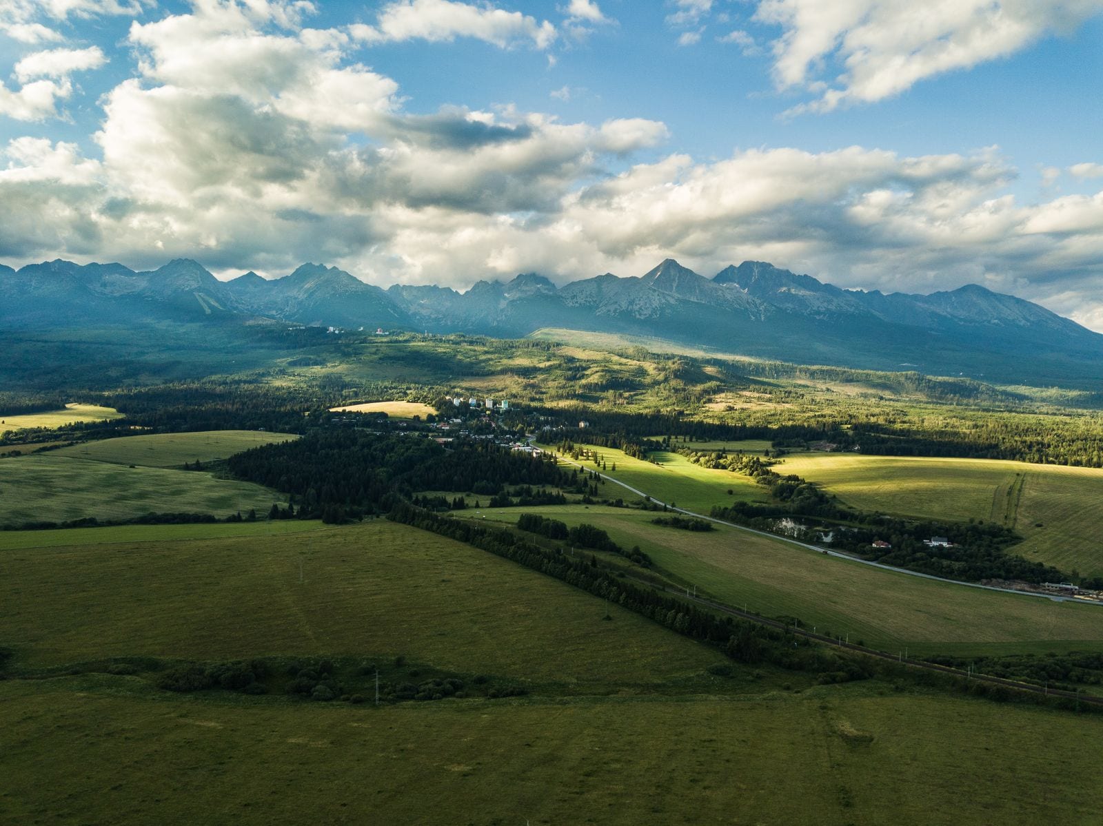 Vysoké Tatry nad poliami pod Tatrami za slnečného dňa