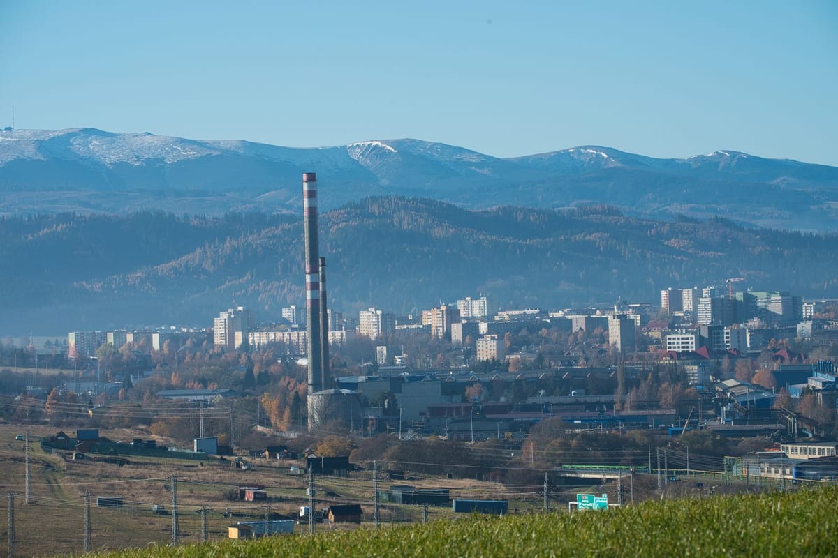 Sídliská a komín v Poprade s horami v pozadí