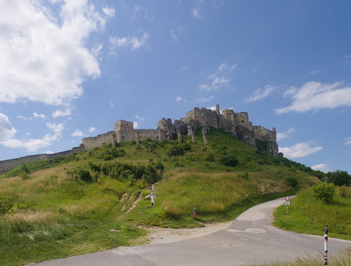 Spišský hrad na kopci a asfaltová prístupová cesta pod ním