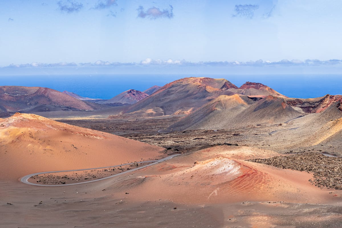 Červené a hnedé sopky s cestou v národnom parku Timanfaya na Lanzarote