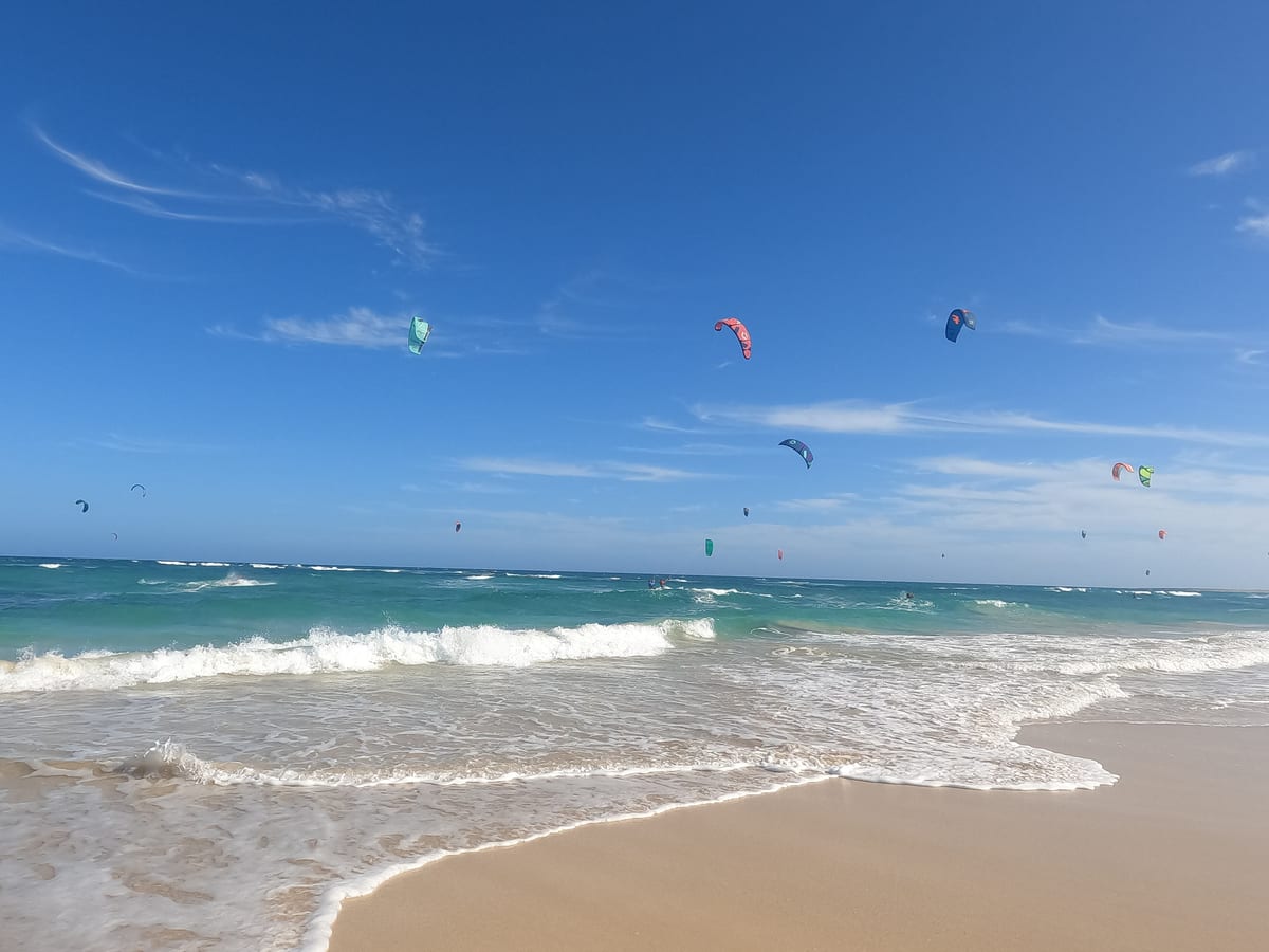 Desiatky kitesurferov nad vlnami na Kite Beach na pobreží Costa da Fragata východne od Santa Marie