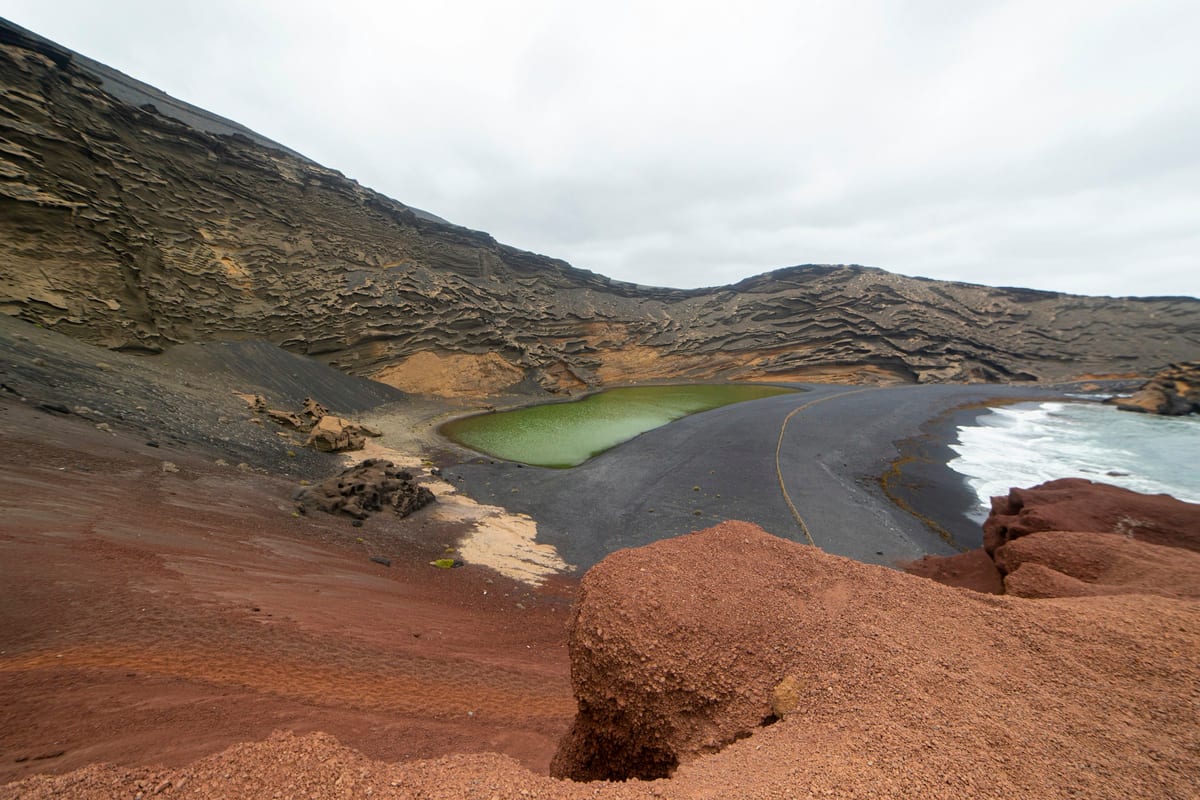 Zelená lagúna Charco de los Clicos pri čiernej pláži El Golfo pod stenou krátera
