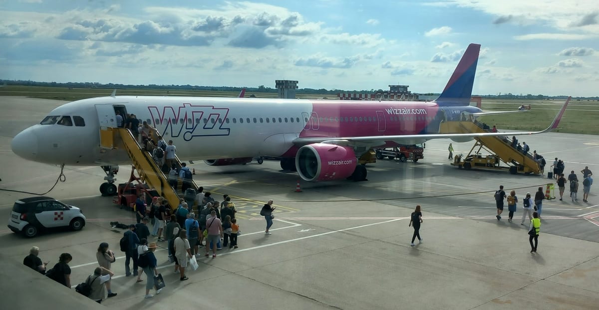 Cestujúci nastupujú po schodoch do lietadla Airbus na odbavovacej ploche letiska v Bratislave
