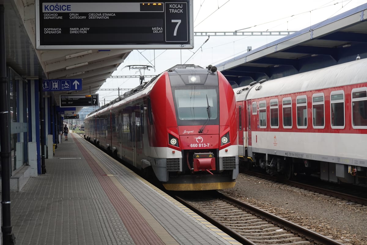 Nástupište železničnej stanice Košice s červenou súpravou a tabuľou na koľaji 7