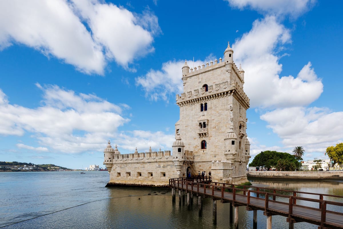 Veža Belém z bieleho kameňa na brehu rieky Tejo s drevenou lávkou