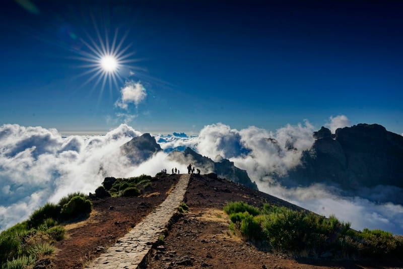 Turisti na dláždenom chodníku na Pico do Arieiro nad morom oblakov