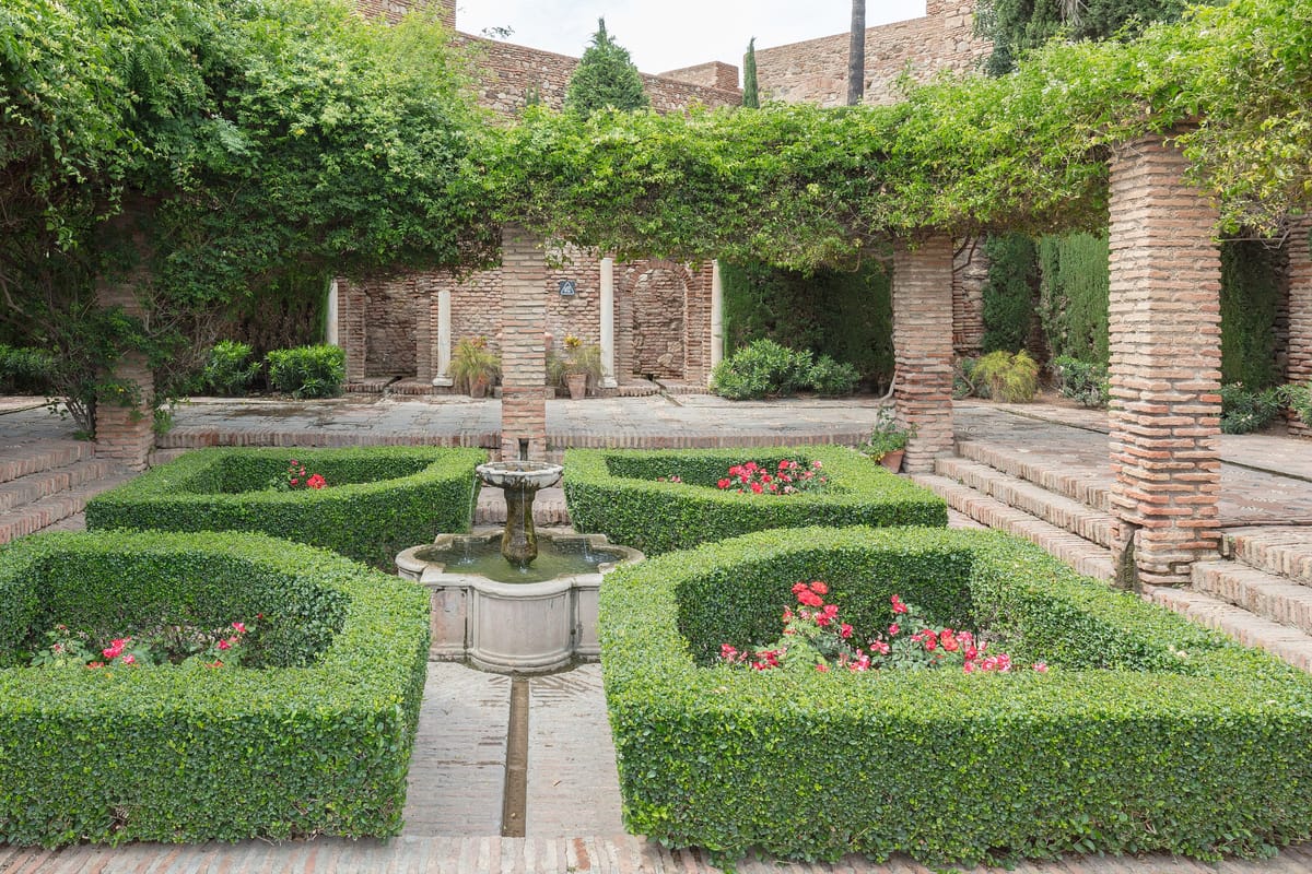 Záhrada s fontánou a živými plotmi na nádvorí paláca Alcazaba