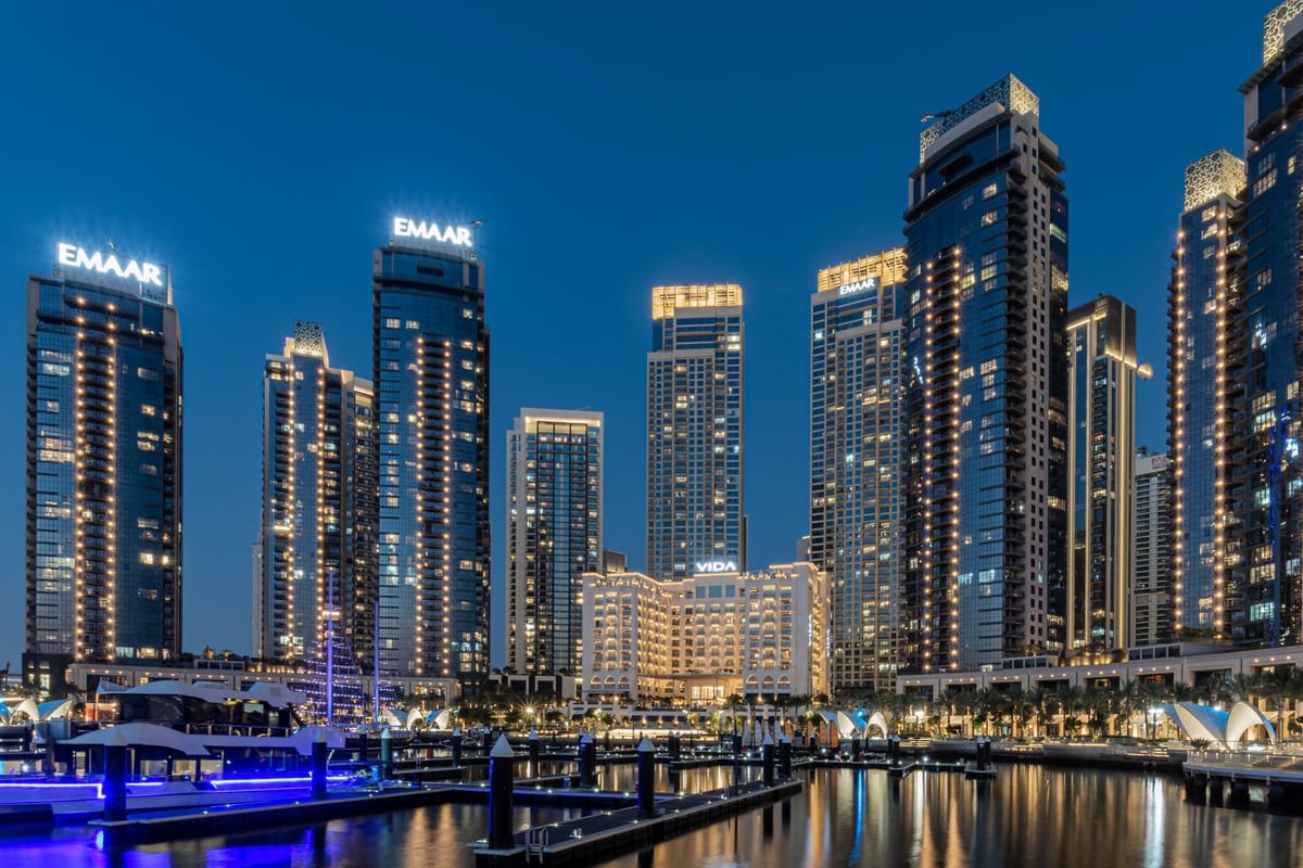 Osvetlené mrakodrapy Dubai Creek Harbour a prístav s mólami po západe slnka