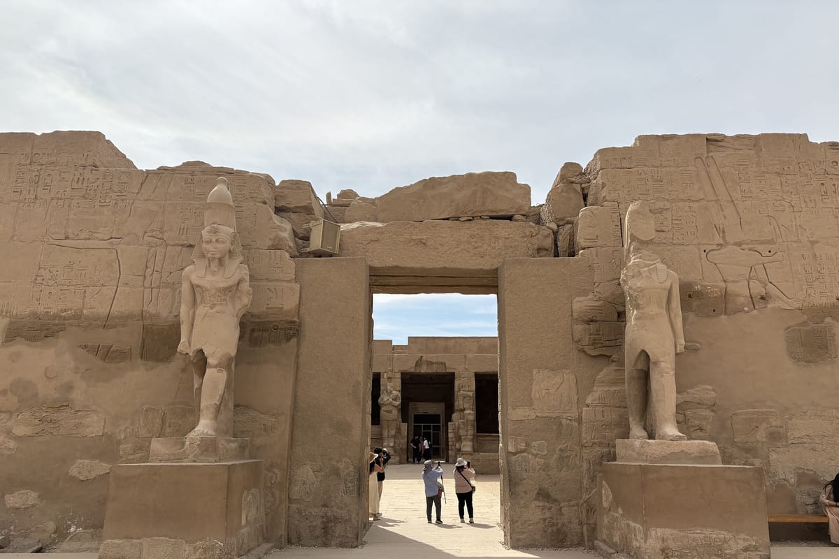 Obelisk a návštevníci v chráme Karnak v Luxore pod zamračenou oblohou vo februári