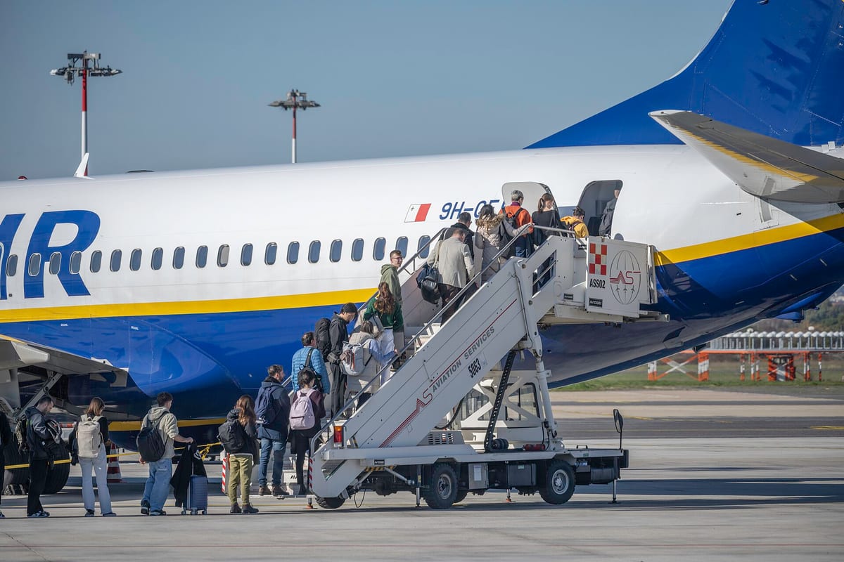 Cestujúci s batožinou nastupujú po zadných schodoch do lietadla Ryanair Boeing 737-800