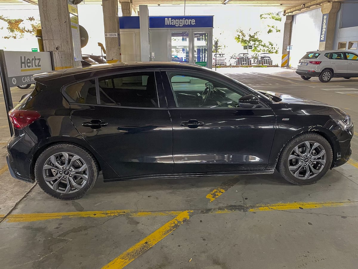 Čierne auto z požičovne zaparkované v krytej garáži pri stanovišti autopožičovne