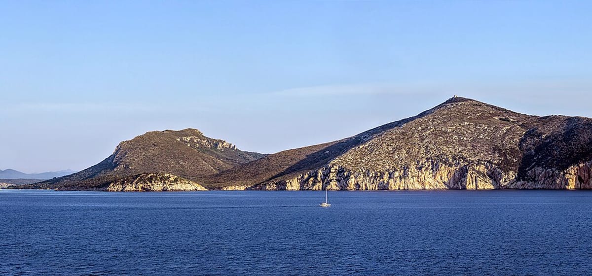 Ostrovček Figarolo a mys Capo Figari pri Olbii, fotené z mora za jasného dňa