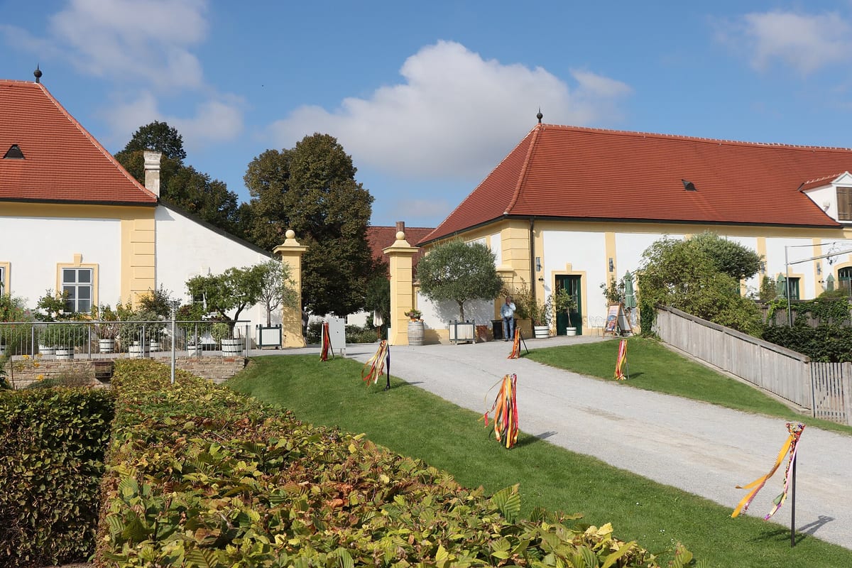 Nádvorie statku Schloss Hof s hospodárskymi budovami a záhonmi