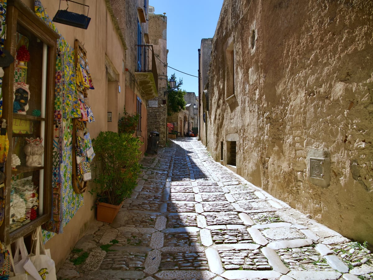 Úzka dláždená ulička v stredovekom Erice s obchodom s keramikou