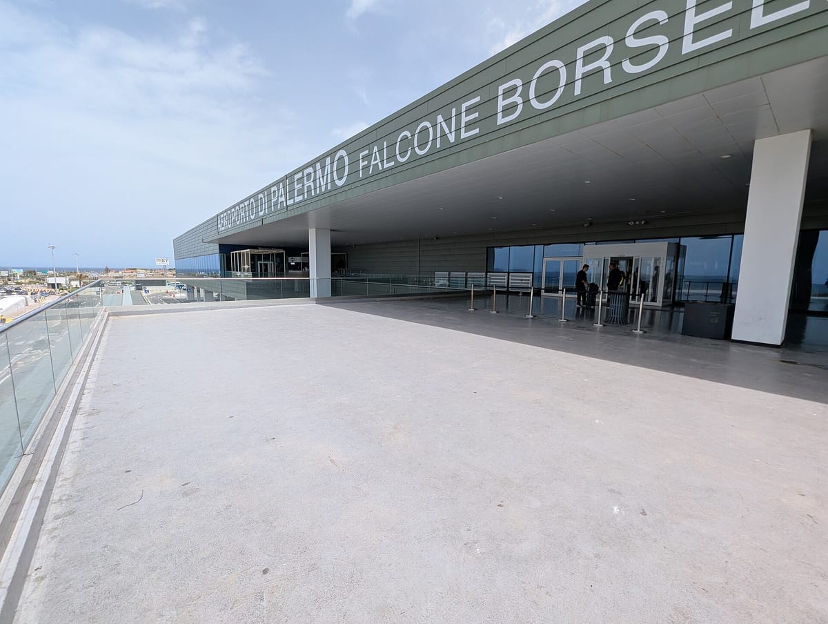 Vchod do terminálu letiska Palermo Falcone Borsellino s nápisom na fasáde a terasou pred odletovou halou