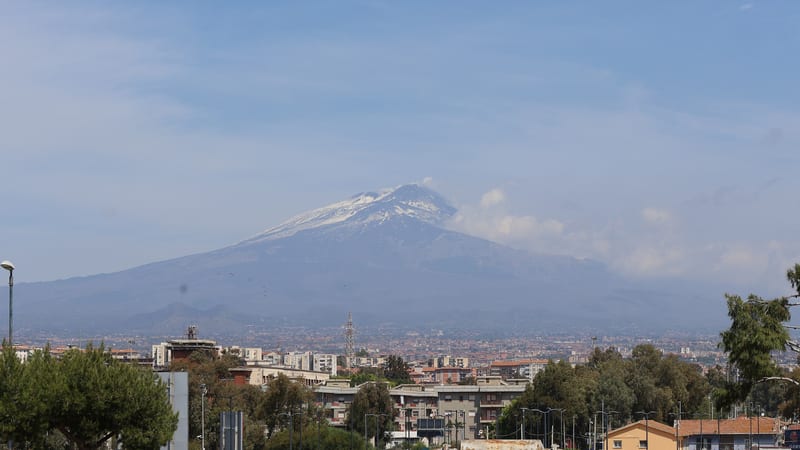 Etna so zasneženým vrcholom nad Cataniou, pohľad z okolia letiska Fontanarossa