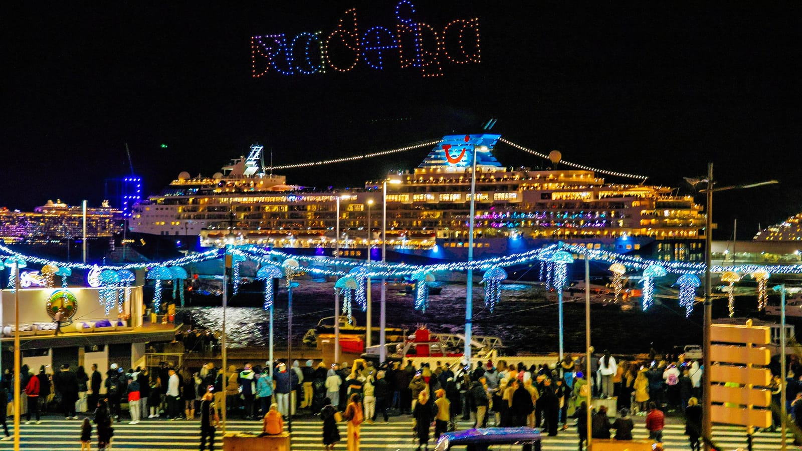 Dronová show nad prístavom vo Funchale na Silvestra 2025, výletné lode a ľudia na nábreží