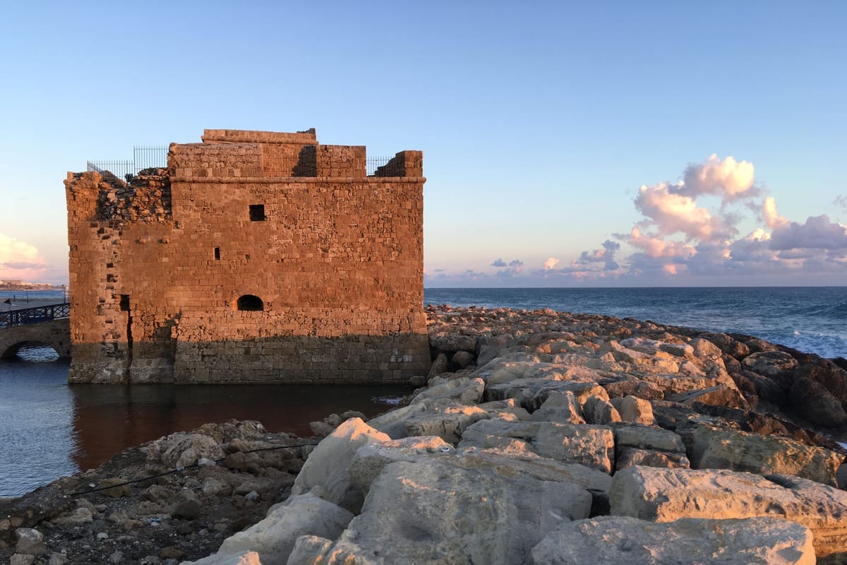 Hrad v prístave Pafos na Cypre pri západe slnka nad Stredozemným morom