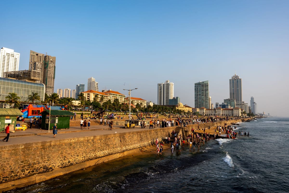 Nábrežie Galle Face Green v Colombe s ľuďmi pri mori a mrakodrapmi v pozadí.