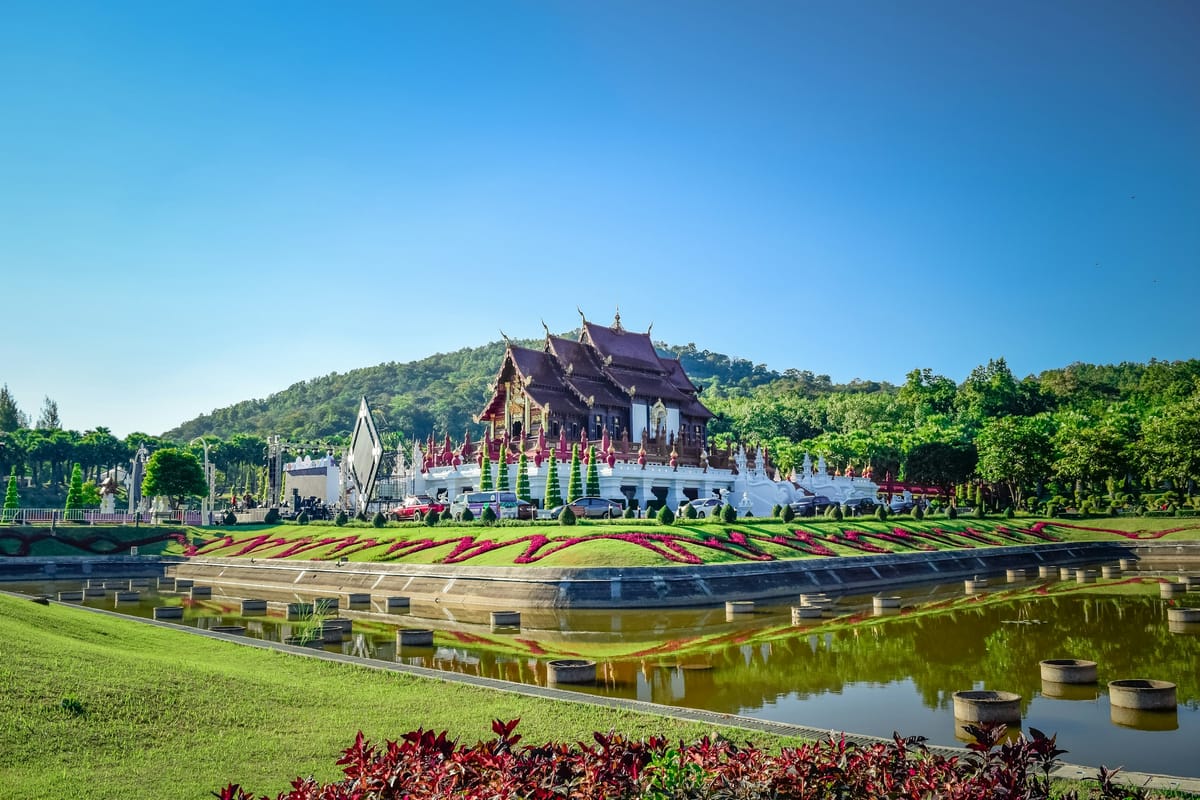 Kvetinové záhony a pavilón v thajskom štýle v parku v Chiang Mai