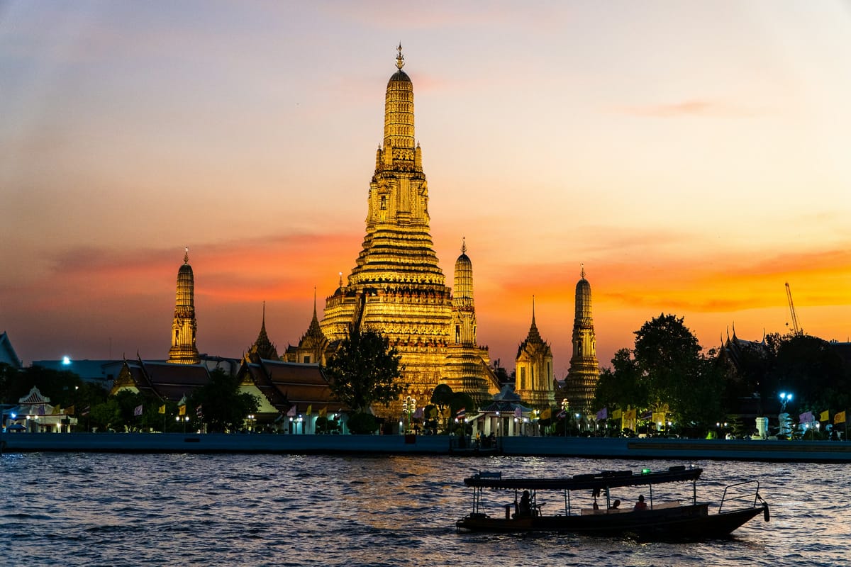 Chrám Wat Arun nad riekou Chao Phraya v Bangkoku pri západe slnka