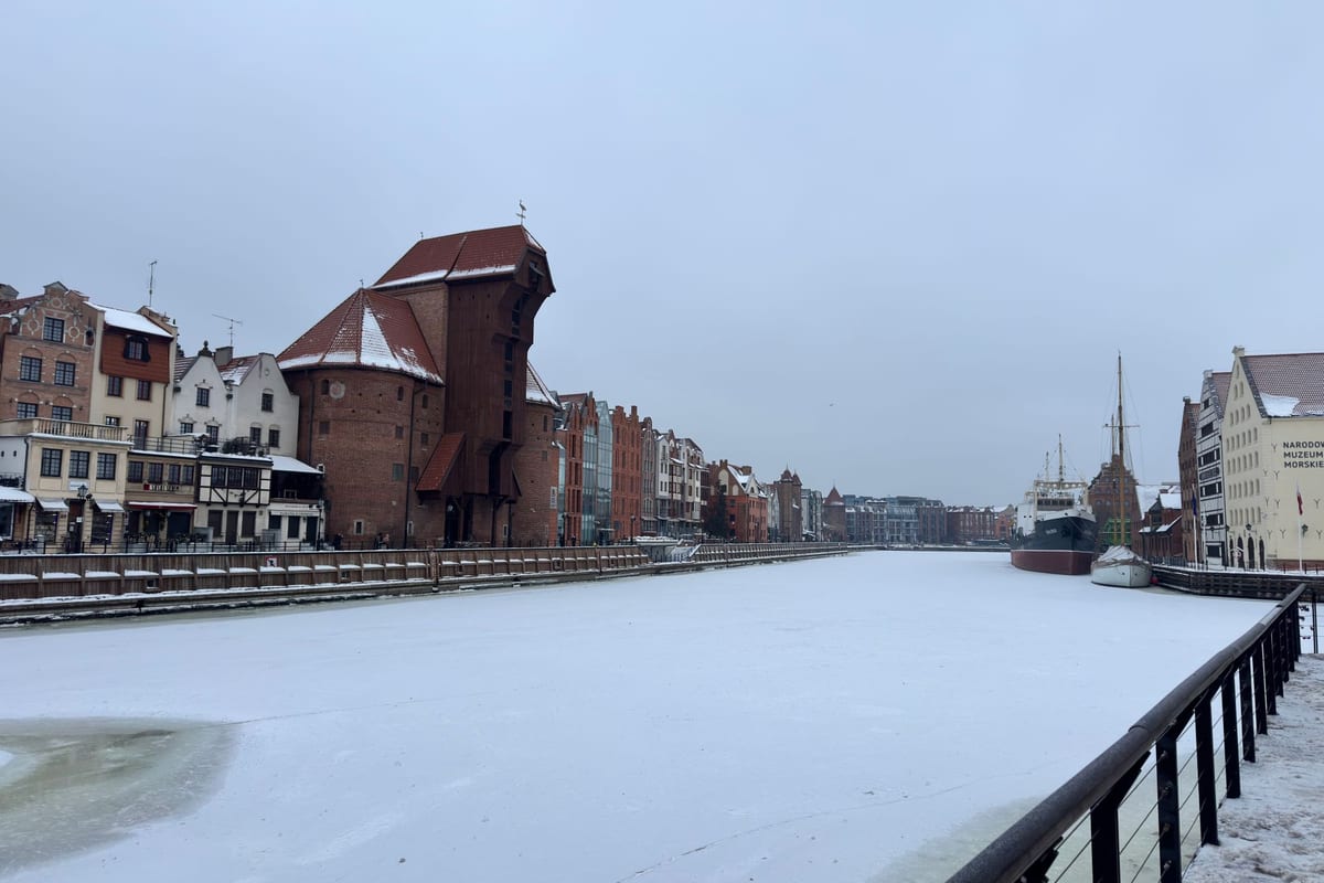 Zamrznutá Motława v Gdansku so snehom, žeriav Żuraw a loď Sołdek v decembrovom mraze