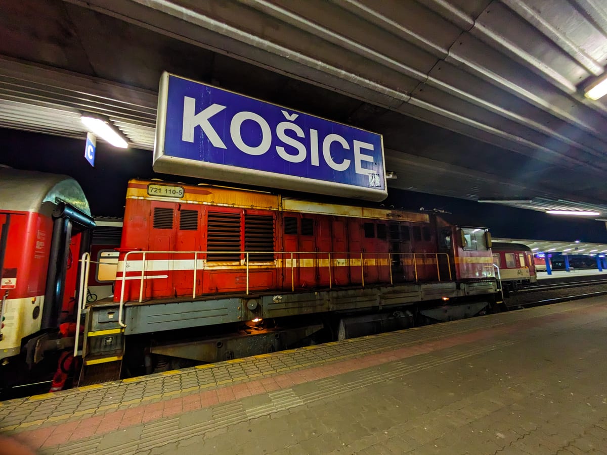Červená motorová lokomotíva ZSSK na nástupišti pod tabuľou Košice na hlavnej stanici