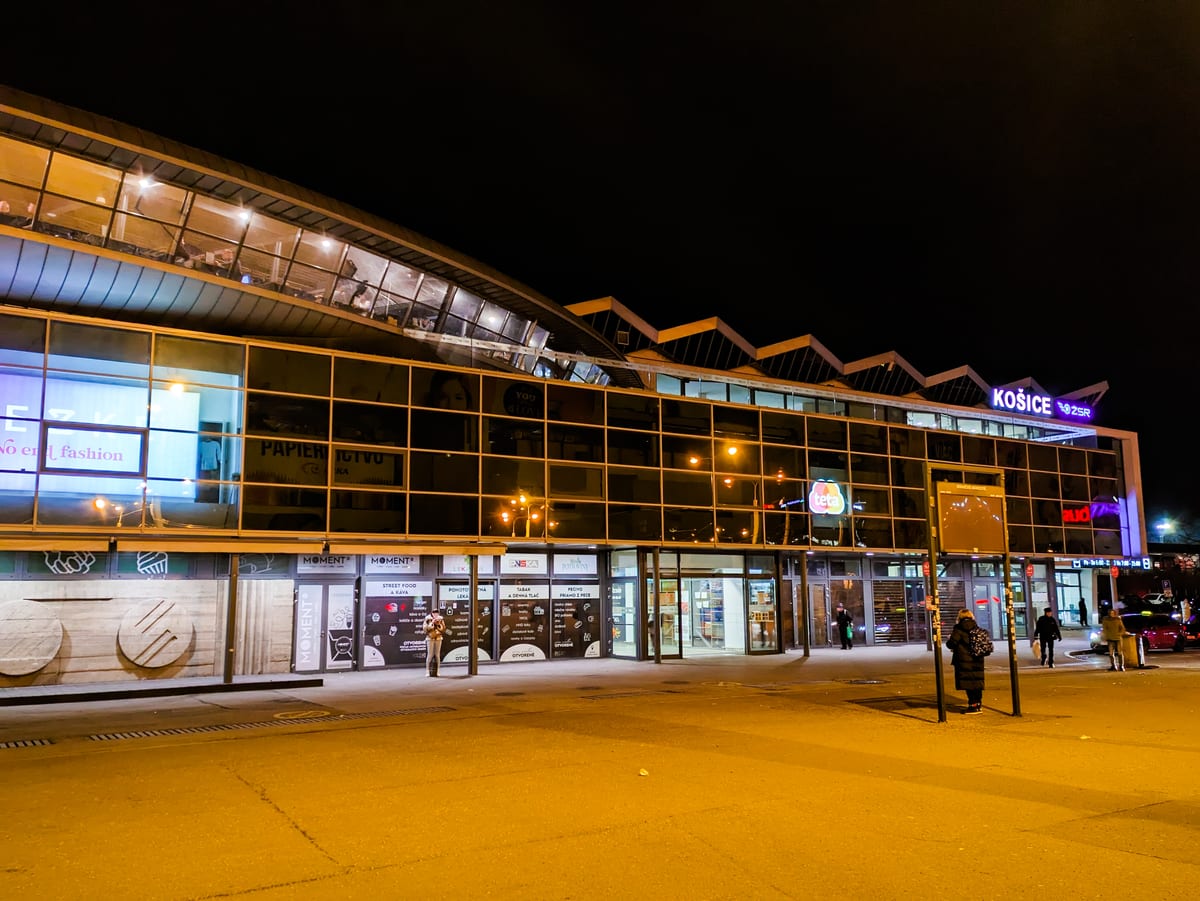Presklená budova železničnej stanice Košice večer s rozsvietenými oknami