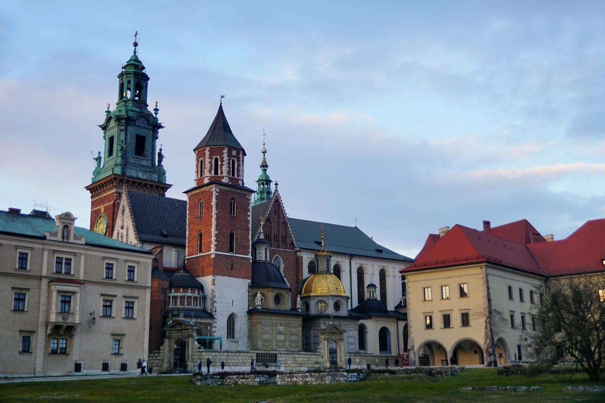 Katedrála a hrad Wawel v Krakove so zelenými vežami pod modrou oblohou