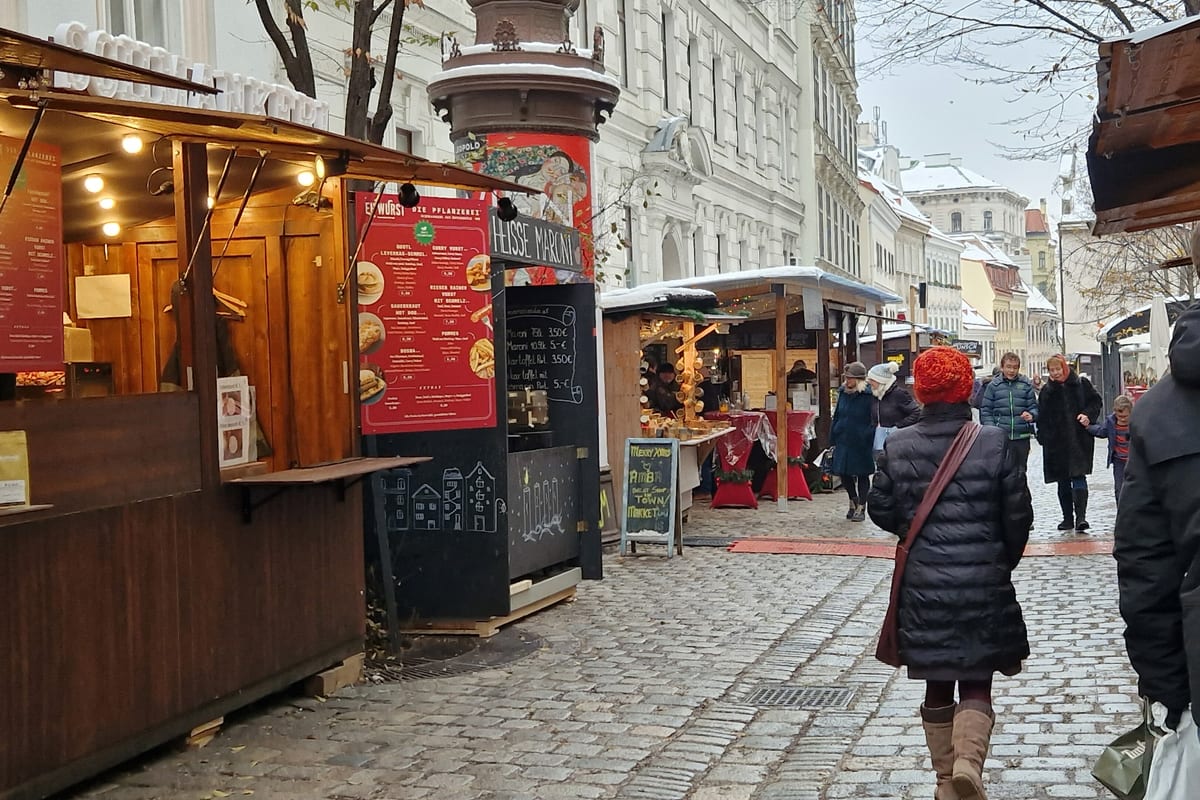 Drevené stánky v úzkej dláždenej uličke na trhu Spittelberg cez deň