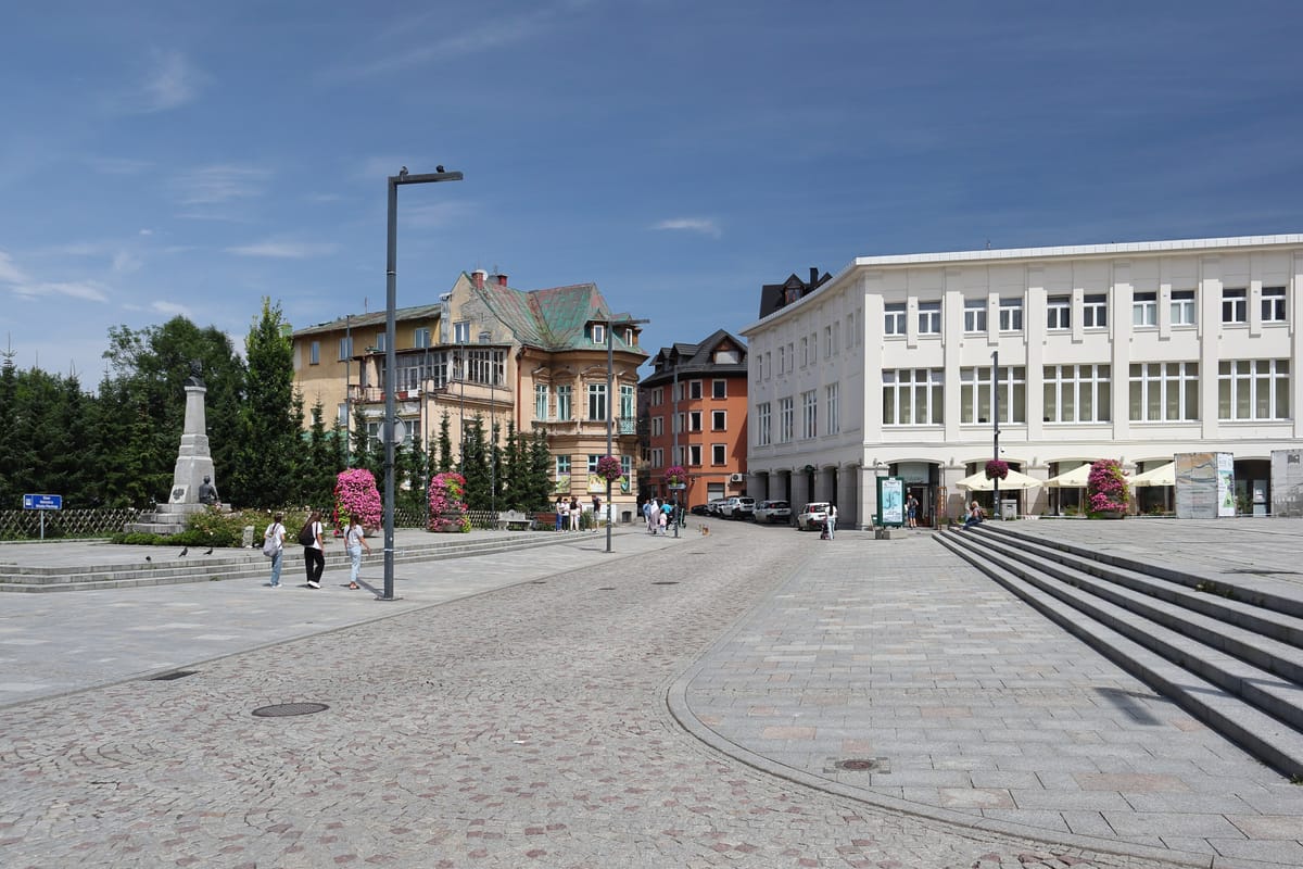 Plac Niepodległości v Zakopanom v lete, v advente na ňom stoja vianočné trhy