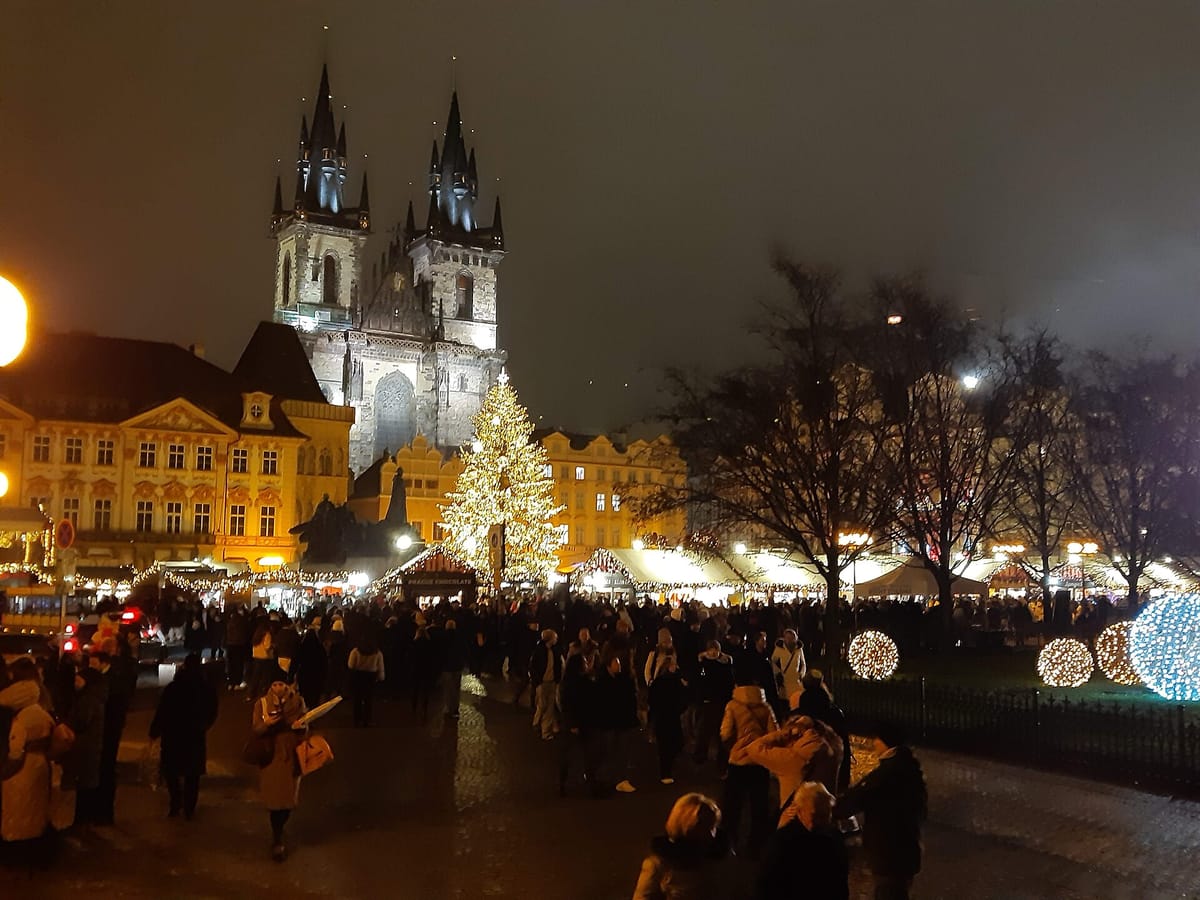 Vianočné trhy na Staromestskom námestí v Prahe s Týnskym chrámom a stromčekom večer