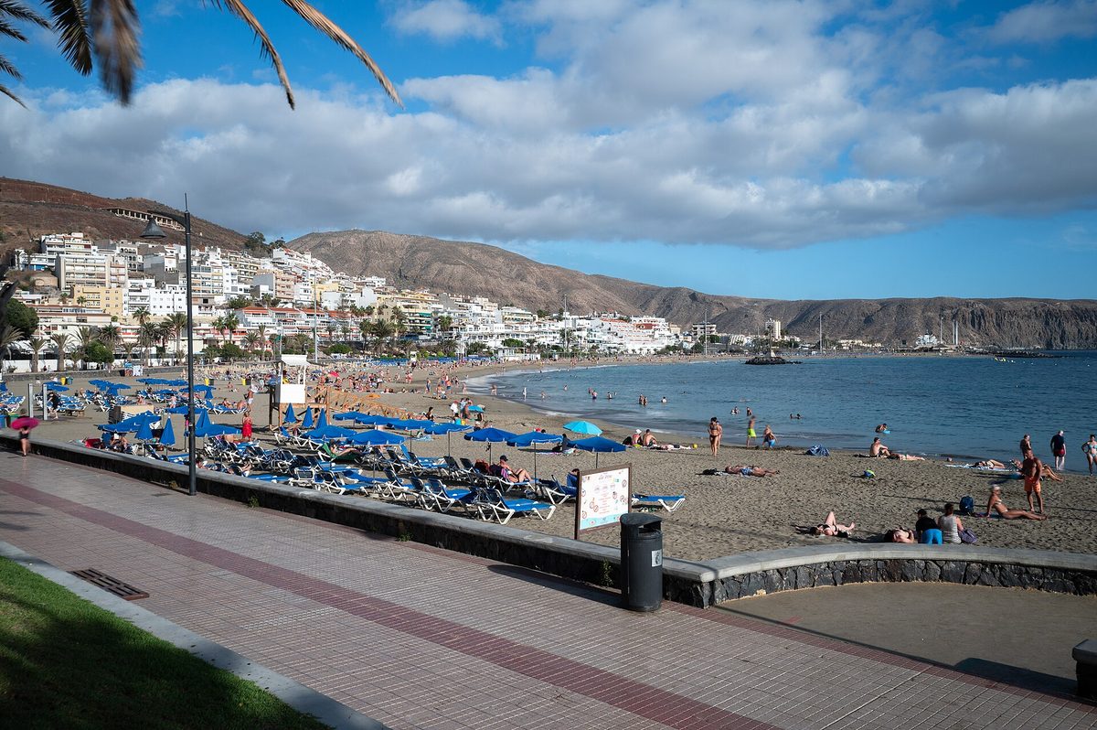 Pláž Las Vistas na juhu Tenerife s lehátkami, promenádou a horami v pozadí