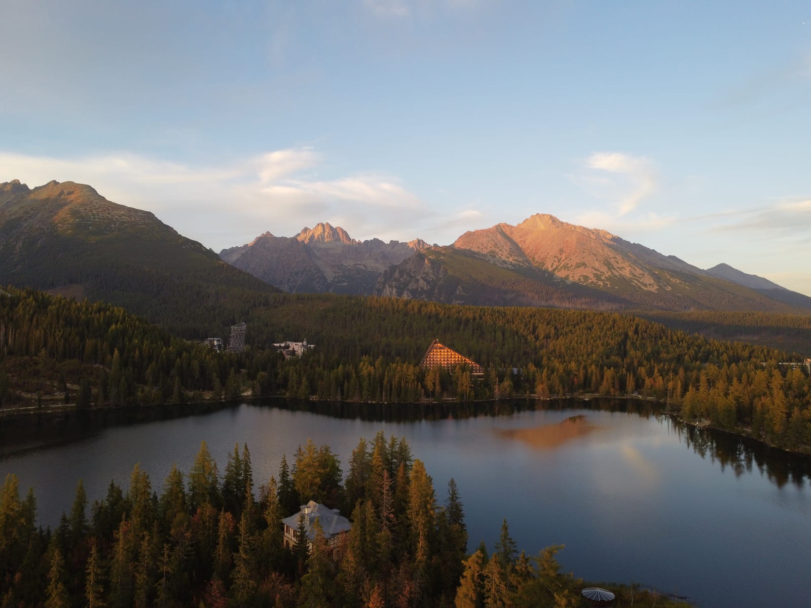 Štrbské pleso pri západe slnka pod štítmi Vysokých Tatier, pohľad z dronu